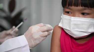 Virüsü koruyan Asyalı doktor enjeksiyon aşısı covid-19 tıbbi maske takıyor
