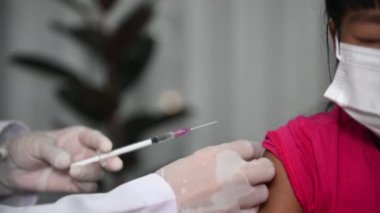 Virüsü koruyan Asyalı doktor enjeksiyon aşısı covid-19 tıbbi maske takıyor