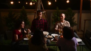 Bahçede parti veren bir grup insan.