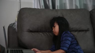 Asyalı küçük kız evde online ödev öğreniyor. Covid-19 epidemi kavramı