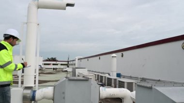 Klima teknisyeni binanın dışındaki birimleri tamir ediyor ve muhafaza ediyor.