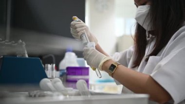 Laboratuvarda çalışan Asyalı bilim adamı ve ürün deneyi yapıyor.