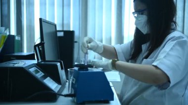 Laboratuvarda çalışan Asyalı bilim adamı ve ürün deneyi yapıyor.