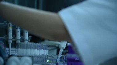 Laboratuvarda çalışan Asyalı bilim adamı ve ürün deneyi yapıyor.