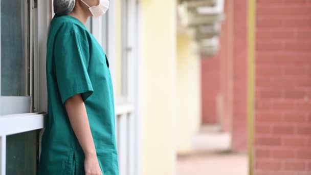 顔のマスクとハードワークからの青い均一なストレスを身に着けている疲れ落ち込んで女性アジアのスクラブ看護師 — ストック動画