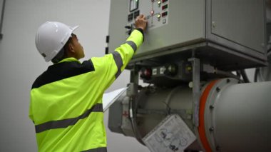 Mühendis bilgisayar işçisi büyük makineleri kontrol ediyor