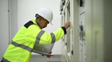 Mühendis bilgisayar işçisi büyük makineleri kontrol ediyor