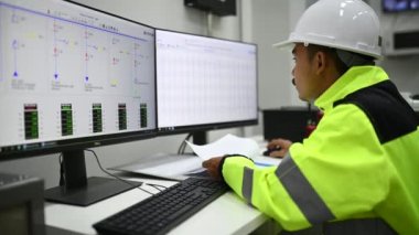 Mühendis bilgisayar işçisi büyük makineleri kontrol ediyor