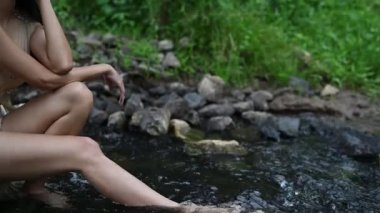 Beyaz iç çamaşırlı, doğaya poz veren Asyalı güzel bir kadının ağır çekimleri.   