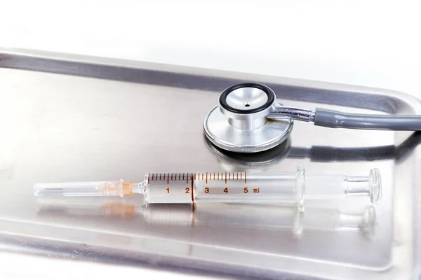 Beautiful stethoscope and glass syringe with reflection — Stock Photo, Image