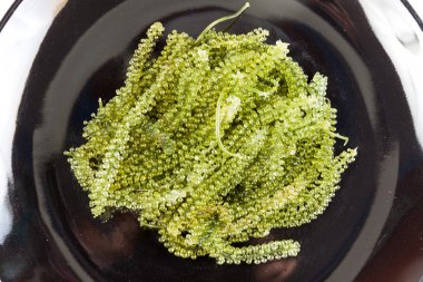 siyah bir tabak üzerinde yeşil havyar