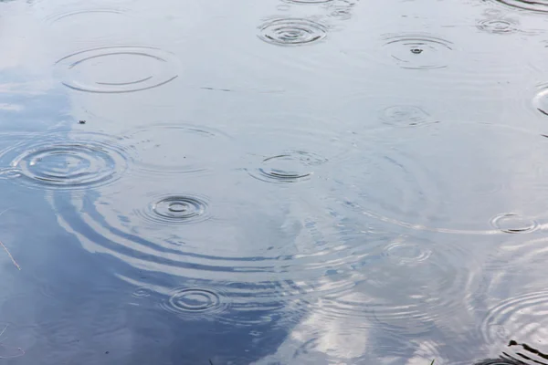 Капли дождя и волны в воде — стоковое фото