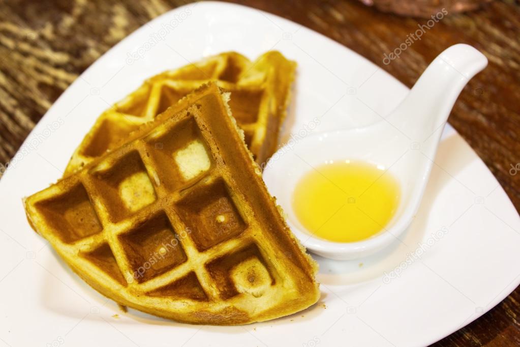 Waffles with honey in white plate