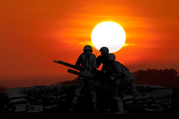 Flak-Maschinengewehr und drei Soldaten in Silhouette — Stockfoto