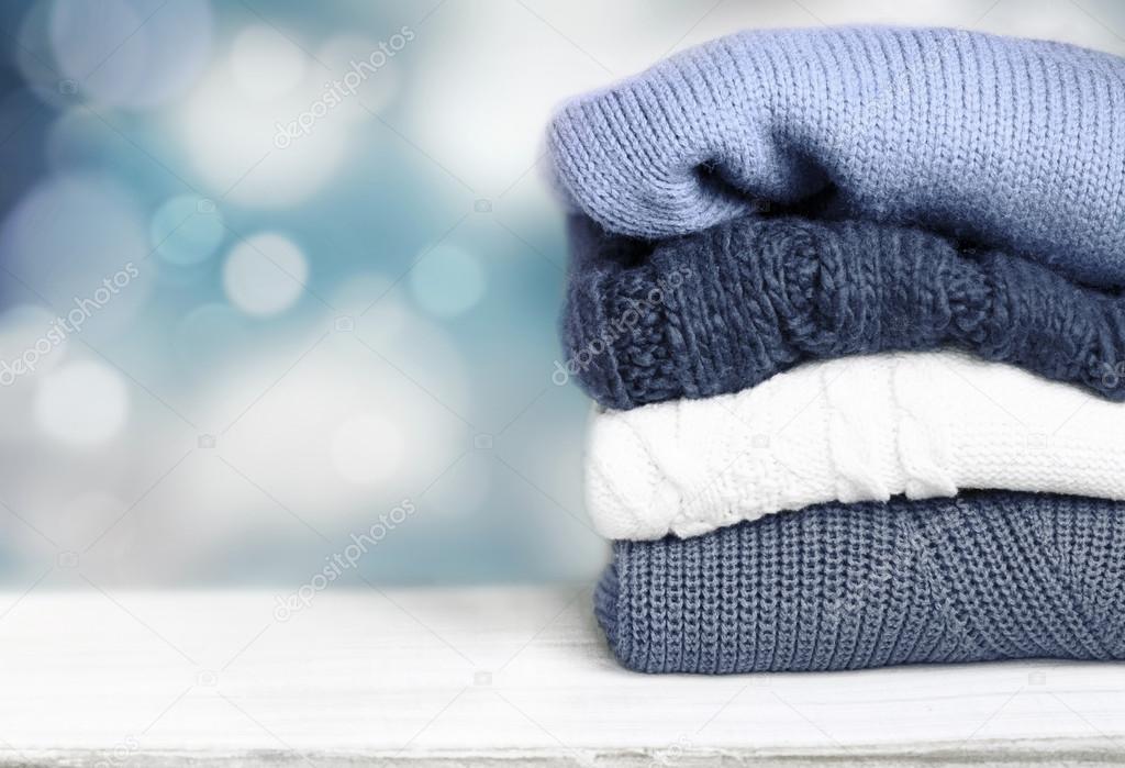 Pile knitted winter autumn clothes on wooden — Stock