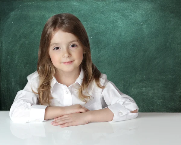 Ребенок девочка на столе мелом фоне доски . — стоковое фото
