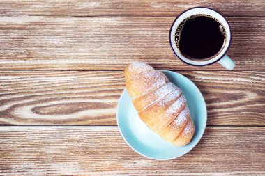 Ahşap arka plan boş kopya alanı üzerinde kahve kruvasan.