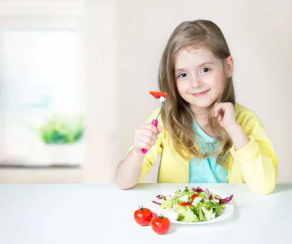 Friska barn kost. Tjej äter sallad på bordet. — Stockfoto