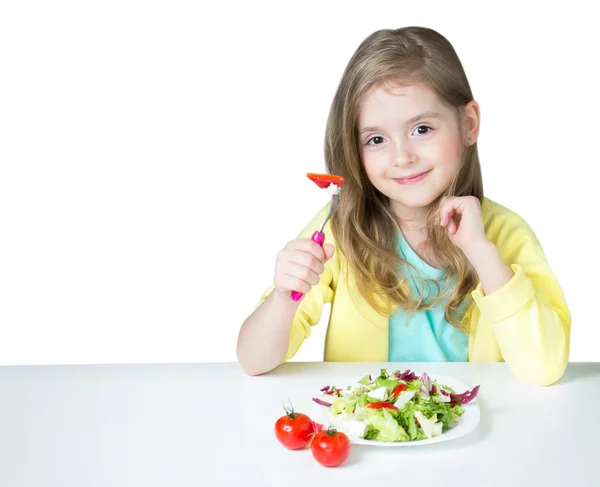 Barn Tjej äter sallad på tabell isolerad på vit. — Stockfoto