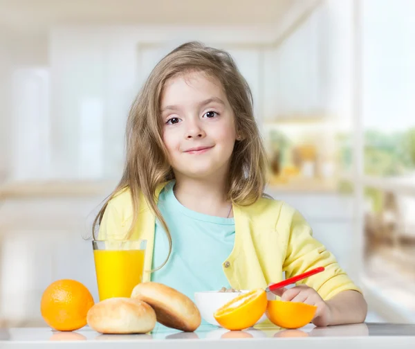 Kind jongen meisje eten op tafel fruit binnenshuis. — Stockfoto