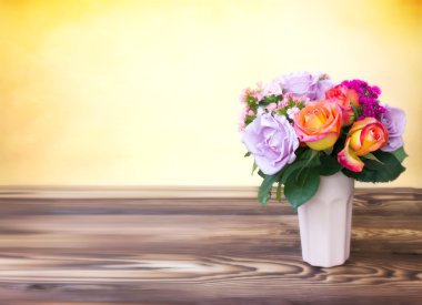 Ahşap masa empy uzay arka plan üzerinde vazoda gül buketi.