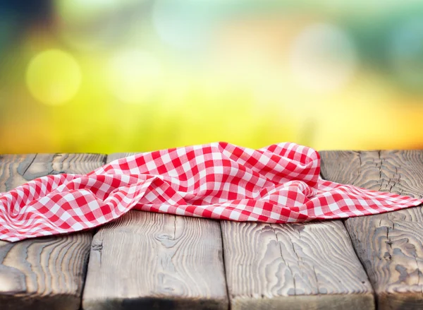Pano de piquenique vermelho na mesa de madeira fundo bokeh maduro . — Fotografia de Stock