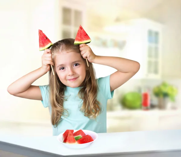 Barn flicka äter vattenmelon inomhus bakgrund tomt utrymme. — Stockfoto