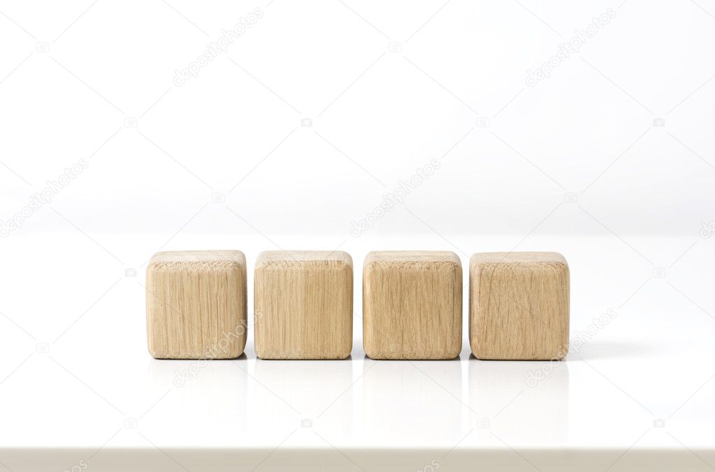 Four wooden cubes on white table.