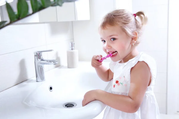 小さな子供はバスルームで歯を掃除します 手に歯ブラシ付きの小さな女の子 — ストック写真