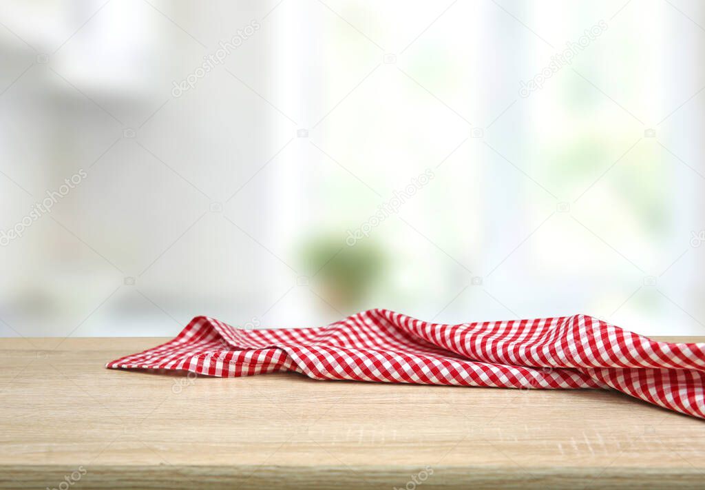 Empty table decorated with red checkered towel food advertisement display. Tabletop with empty space. Picnic table on wooden deck,blurred backdrop. Promotion background.
