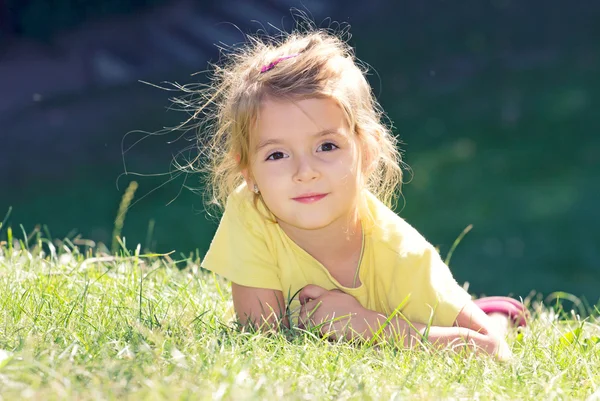 緑 grass.child 屋外クローズ アップ顔の上に横たわる少女 — ストック写真