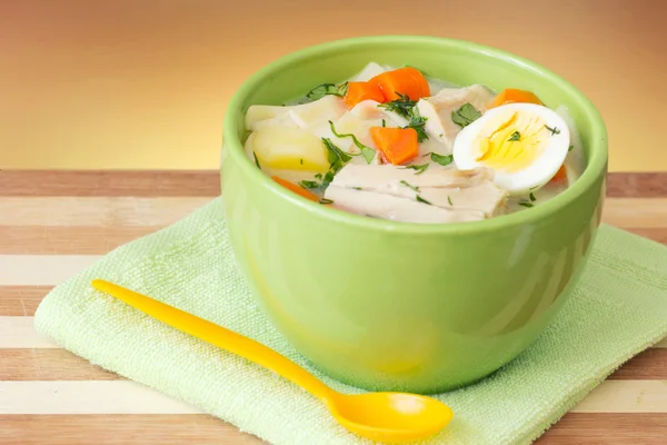 Chicken soup bowl with spoon closeup on wooden. — Stock Photo, Image