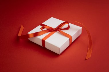 Kırmızı kurdeleyle süslenmiş beyaz hediye kutusu. Noel hediyesi. Tek itiraz. Terfi, indirim. Sevgililer Günü..