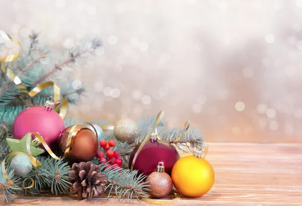 Xmas holiday background. Fir& balls on wood with blurred backdro — Stock Photo, Image