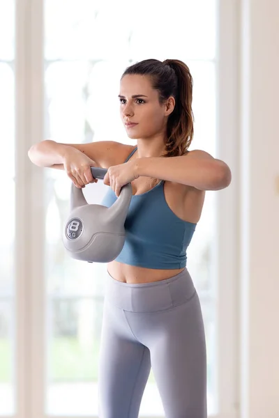 Jonge Vrouw Doet Thuis Workout Met Kettlebell Stockafbeelding