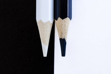 Siyah-kırmızı arka planda siyah-beyaz kalemler.