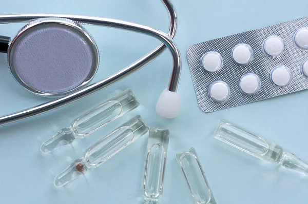 ampoules, tablets, blood pressure monitor, set on a blue background