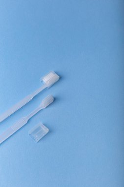 Mavi arka planda beyaz diş fırçaları. Ağız bakımı, sakız ve diş sağlığı. Sabah rutini ve sağlık hizmetleri.