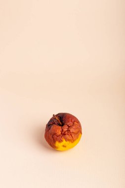 Bej arka planda çürük elma. Bozuk yemek. Çürük meyveler.