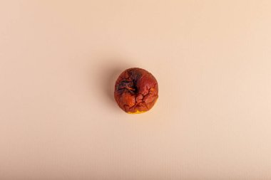 Bej arka planda çürük elma. Bozuk yemek. Çürük meyveler.