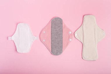 Pembe arka planda yukarıdan kullanılabilir pedler. Kadınlar için hijyen. Regl döneminde kadınlar için özel pedler. Regl döneminde kadınlar için hijyen ve koruma ürünleri.