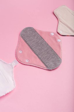 Pembe arka planda yukarıdan kullanılabilir pedler. Kadınlar için hijyen. Regl döneminde kadınlar için özel pedler. Regl döneminde kadınlar için hijyen ve koruma ürünleri.