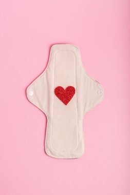 Pembe arka planda yukarıdan yeniden kullanılabilir ped. Kadınlar için hijyen. Regl döneminde kadınlar için ped. Regl döneminde kadınlar için hijyen ve koruma ürünleri.