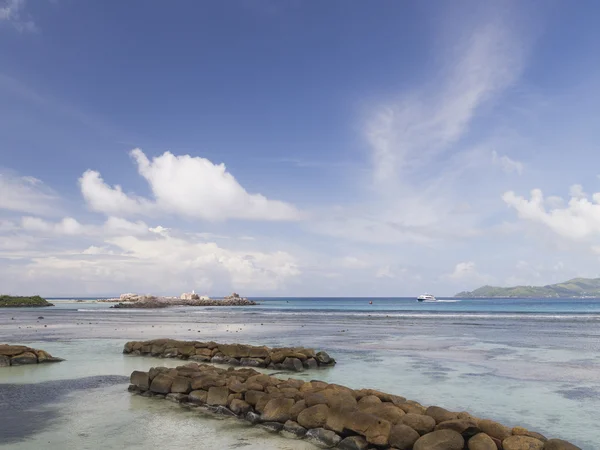 Яркий морской пейзаж с волнорезом из камней — стоковое фото