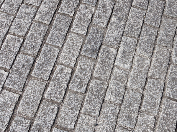 Old gray granite paving slabs with old gray seams on the street