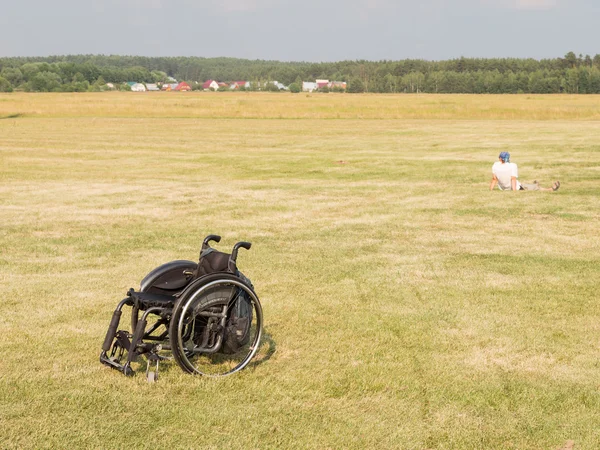 Tekerlekli sandalye ve çim üzerinde oturan kişi, Moskova regio Telifsiz Stok Imajlar