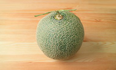 Taze olgun Muskmelon ya da kavunlu kavun meyvesi. Kökü ahşap masada yalıtılmış.