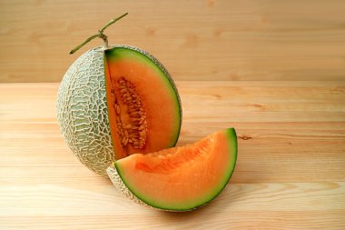 Turuncu Taze Olgun Muskmelon, Tahta Masa 'ya izole edilmiş tüm meyvelerden dilimlenmiş.