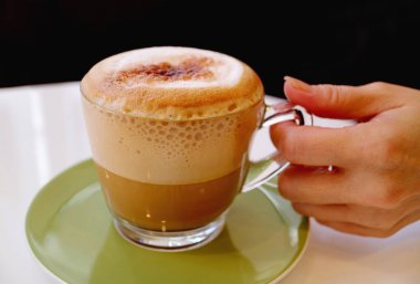 Bir bardak ağız sulandıran köpüklü cappuccino kahvesi.