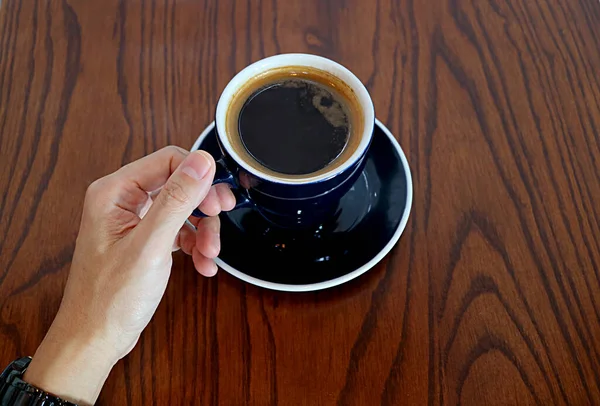 Χέρι Του Ανθρώπου Κρατώντας Κύπελλο Του Ζεστού Καφέ Σερβίρεται Ξύλινο — Φωτογραφία Αρχείου